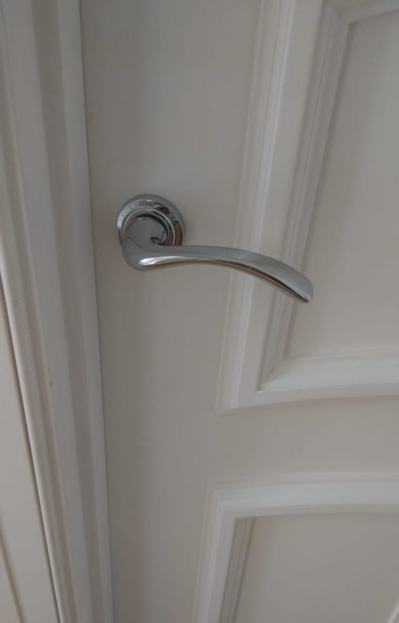 Chrome handle on a while door